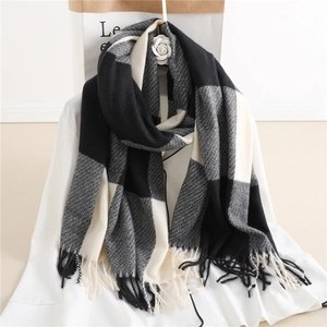 Detail of checkered cashmere-feel scarf with fringes in black, white, and grey pattern