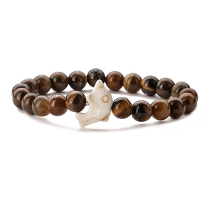 Handmade tiger eye beaded bracelet featuring a white dolphin charm on a white background