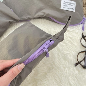 Detail of waterproof travel organizer bag with grey nylon fabric and purple zipper