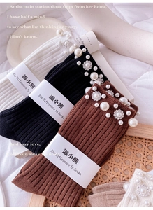 Close-up of ribbed cotton socks featuring elegant pearl and rhinestone flower embellishments