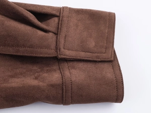 Close-up of dark brown suede jacket sleeve with detailed stitching and soft texture