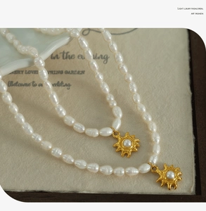 Close-up of freshwater pearl necklace with gold sunflower pendant on artistic card