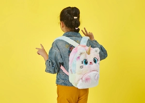 Detail view of colorful tie-dye plush cat unicorn backpack with golden horn on model