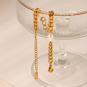 Detail of 18K gold plated Cuban chain bracelet with elegant white freshwater pearl