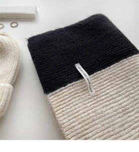 Detail of thick knit scarf with black and white color block and vertical stripe texture