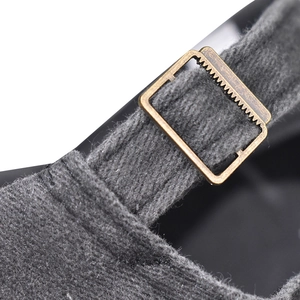 Detailed close-up of the vintage bronze metal buckle on a dark grey washed cotton baseball cap