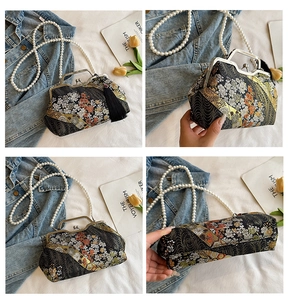 Detail of vintage shell bag with floral embroidery, pearl chain, and metal clasp