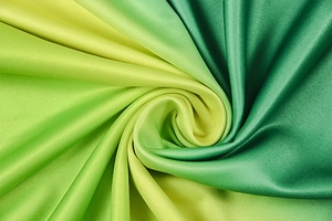 Macro shot of green gradient pleated fabric texture with high silk-like glossy finish
