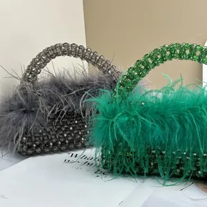 Detail of beaded evening bags with vibrant ostrich feathers in green and grey colors