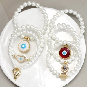 Evil Eye Perlenarmband-Set mit goldenen Herzanhängern in einer weißen Schale