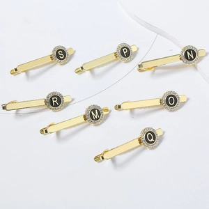 Gold letter tie clips with rhinestones for men featuring alphabets from S to Q on white background