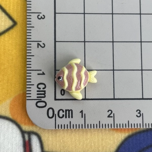 Vista macro dettagliata di una perla a forma di pesce rosa da 1,5 cm su un righello