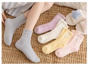 Detail of soft coral fleece socks with ribbon bow ties in pastel pink and grey colors