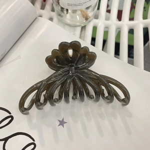 Detail shot of a large resin hair claw clip in translucent grey-brown with wave texture
