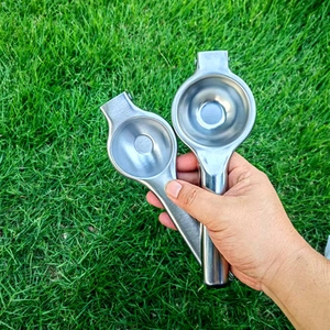 Outdoor close-up of two stainless steel manual citrus juicers in different sizes