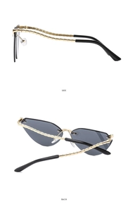 Detail view of cat eye sunglasses with gold bamboo-textured metal temples and black lenses