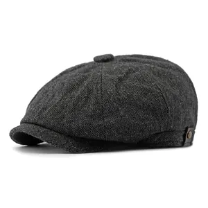 Classic dark grey newsboy cap in herringbone tweed fabric with top button and leather detail