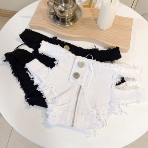 Nahaufnahme von Low-Waist-Jeansshorts mit Fransen und Distressed-Look in Schwarz und Weiß