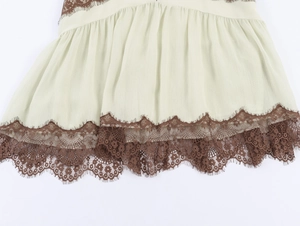 Detail of sheer chiffon fabric with intricate brown floral lace hem on short dress