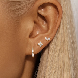 Macro shot of 925 silver gold-plated hoop earrings and petal studs with marquise zircons