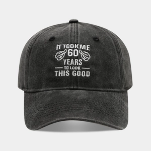 Detail of dark grey washed denim baseball cap with white '60 Years' embroidery and thumb graphic