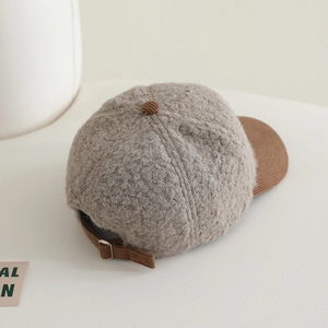 Détail de la boucle en métal sur la casquette en polaire grise et velours côtelé