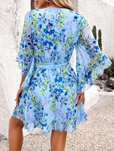 Rear view of floral chiffon dress with bell sleeves and ruffle hem against a white wall