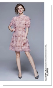 Close-up of pink lace ruffle dress with Peter Pan collar and pearl embellishments