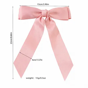 Pink satin ribbon bow hair clip with 15cm width dimensions shown on white background