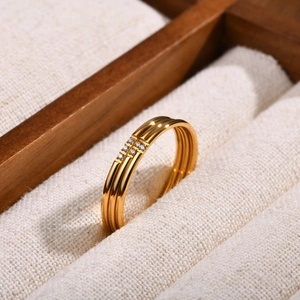 Three-piece gold geometric ring set with sparkling zircon stones in a jewelry box