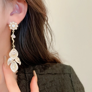 Close-up of elegant long pearl earrings with zircon flowers on model showing drop detail