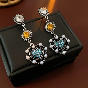 Detailed shot of vintage heart drop earrings with colorful rhinestones and pearls