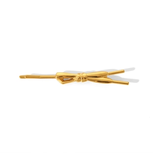 Dettaglio di un fermaglio per capelli in metallo dorato con fiocco dal design moderno