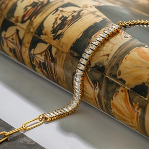 Detail of 18k gold stainless steel bracelet featuring rectangular zircon and paperclip link
