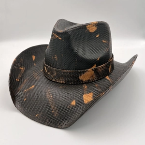 Detail of black cowboy hat featuring vintage orange distressed spray effect and woven texture