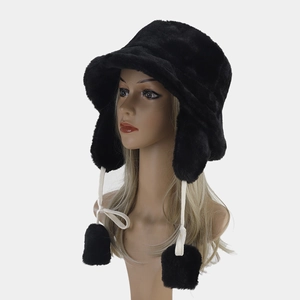 Close-up of thick black faux fur trapper hat with earflaps and white pom-pom ties