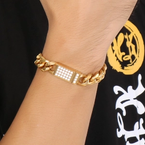 Détail d'un bracelet gourmette doré pour homme avec une barre sertie de zircons brillants