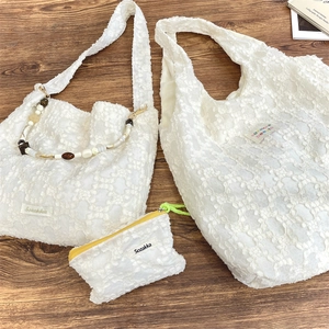 Détail du set de sacs en dentelle blanche à fleurs avec chaîne décorative perlée