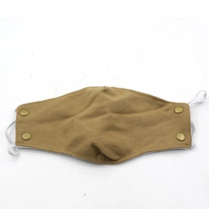 Close-up of khaki winter earflap hat with thick cotton fabric and bronze metal buttons