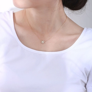 Close-up of gold snowflake pendant with sparkling crystals on a delicate necklace chain