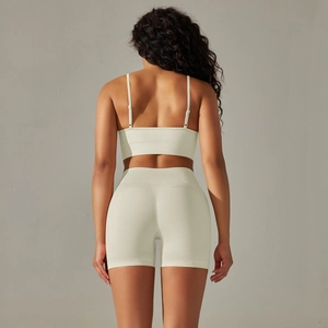 Detail von nahtlosem geripptem beigem Yoga-Set mit Rückansicht von Sport-BH und High-Waist-Shorts