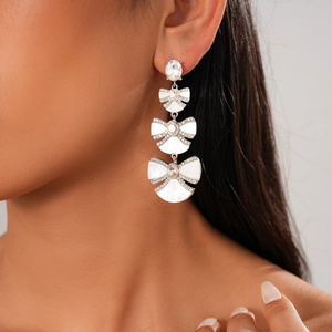 Detailed close-up of an elegant silver bow earring with pavé diamonds on a model