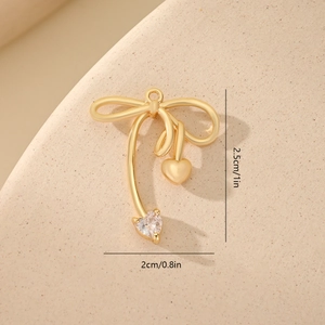 Macro shot of gold bow heart charm with dimensions 2.5cm by 2cm for DIY jewelry