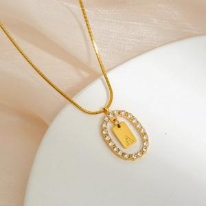 Detailed macro view of the gold-plated oval pendant with paved zircons and letter A