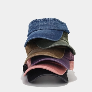 Detailed stack of multi-color washed denim sun visors on a neutral background