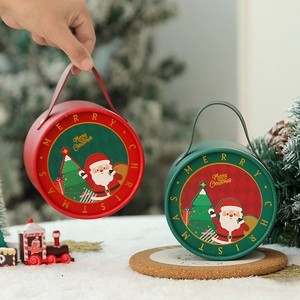 Detail of round Christmas tin gift boxes with Santa patterns and metal handles
