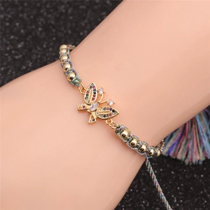 Detail of adjustable woven butterfly bracelet with colorful zircon stones on gold charm