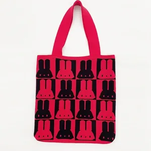 Detail of red and black checkered knitted tote bag with cute rabbit jacquard pattern
