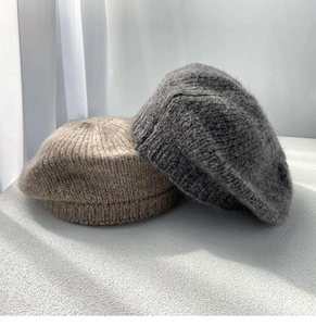 Detail of soft mohair knit texture on light brown and dark grey winter beret hats