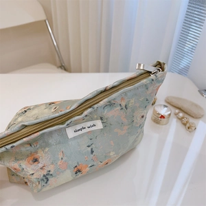 Detail of floral jacquard fabric on vanity bag with metal zipper and woven label